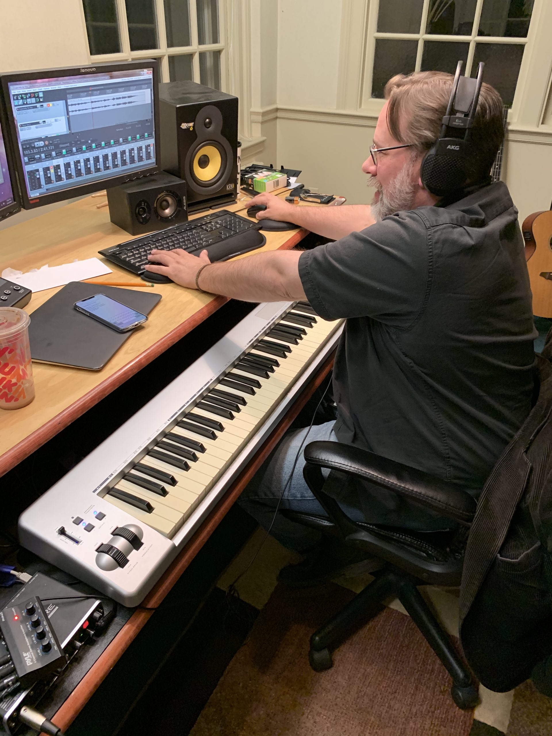 Image from a recording session inside a studio with a man manipulating a computer recording software