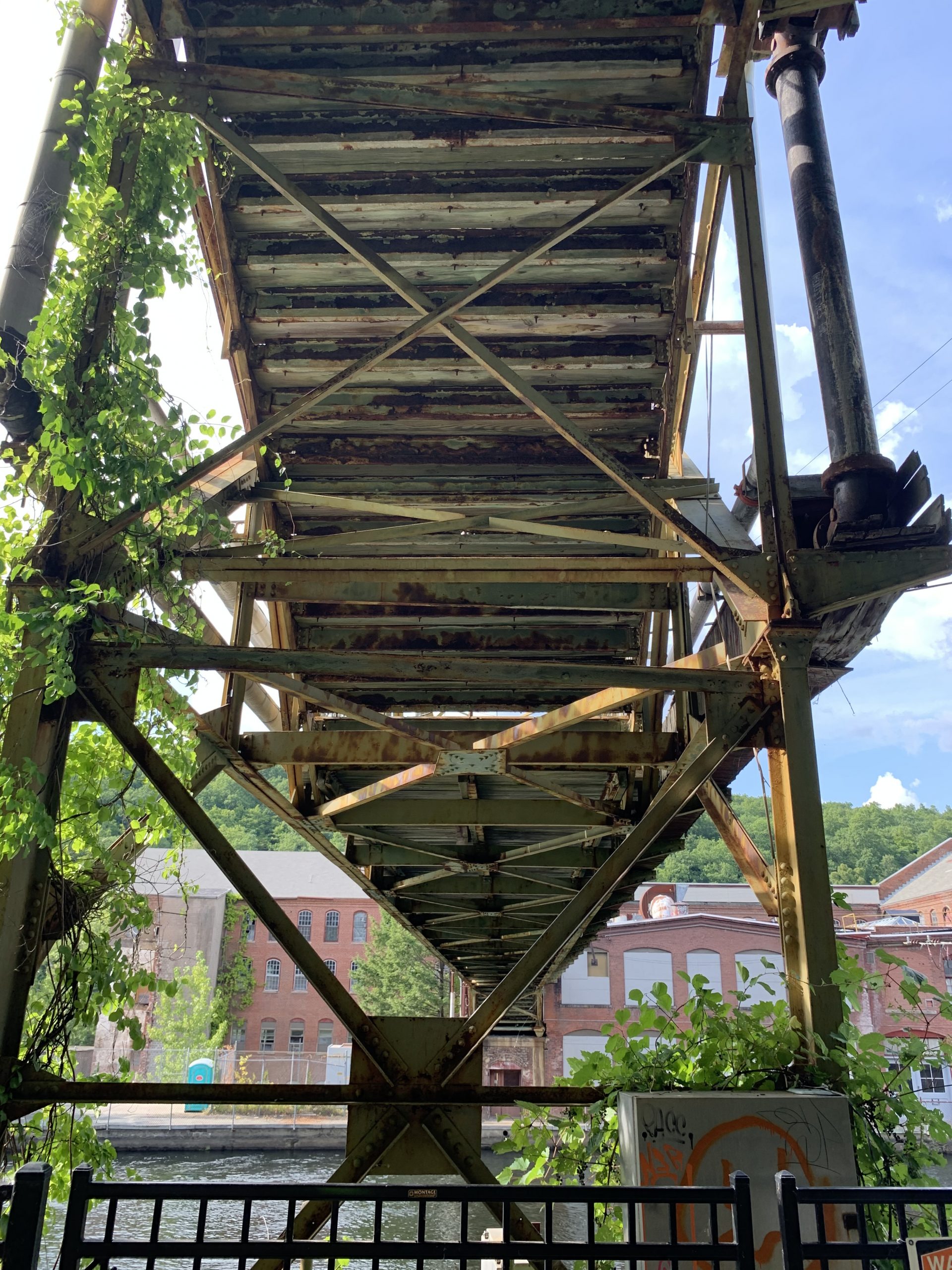 Workers walk bridge, Turners Fall, MA example of post-industrial blight due to ultra-capitalism