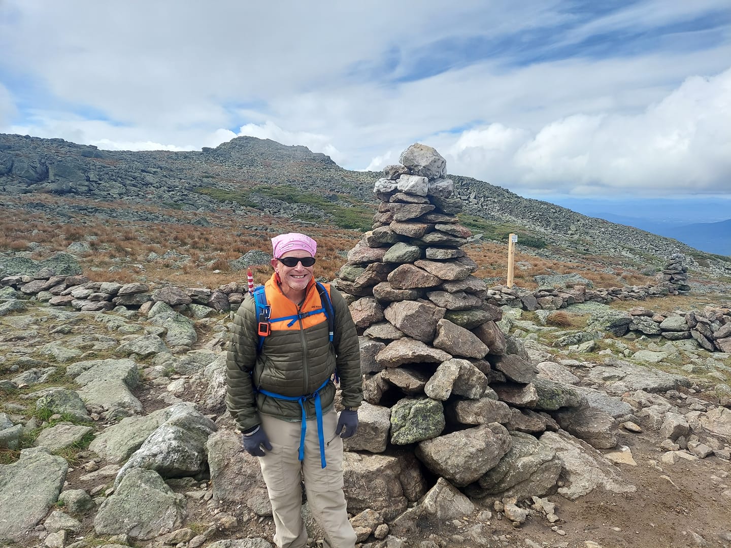 Eric Beaudry in the White Mountains of New Hampshire standing next to a stone Cairn