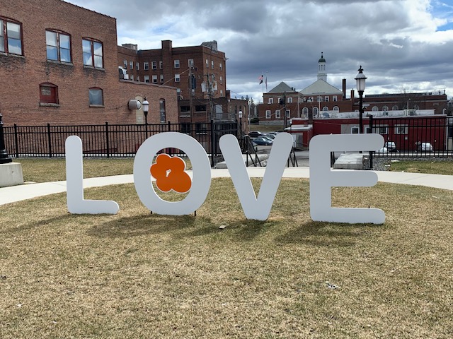 Close-up taken from the Gardner, MA 'Love' sign currently housed in center of the city. White and Orange cut-out signs of each letter in the word love.