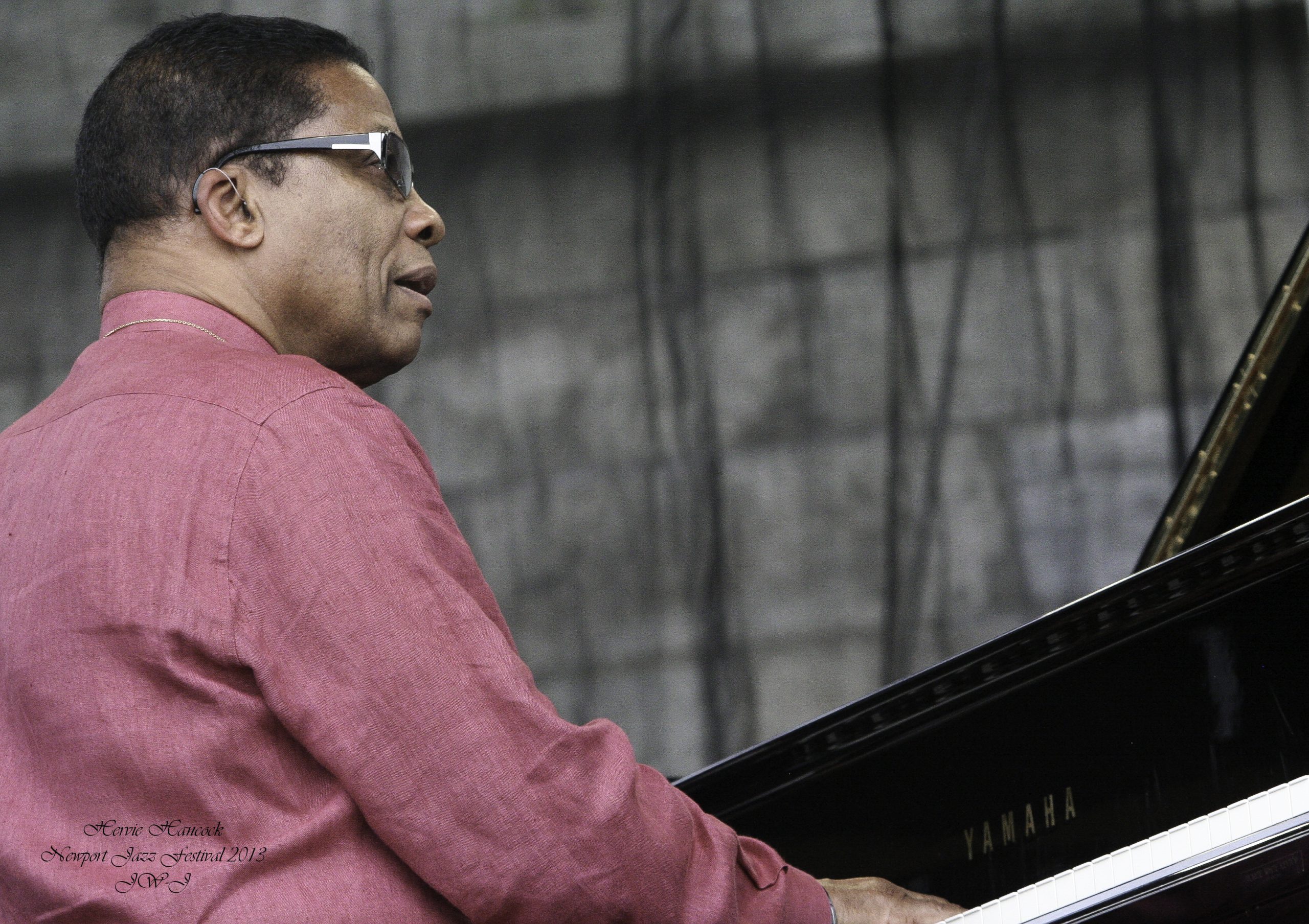 The legend Herbie Hancock, picture taken 3/4 behind and performer behind the piano performing at the Newport Jazz Festival
