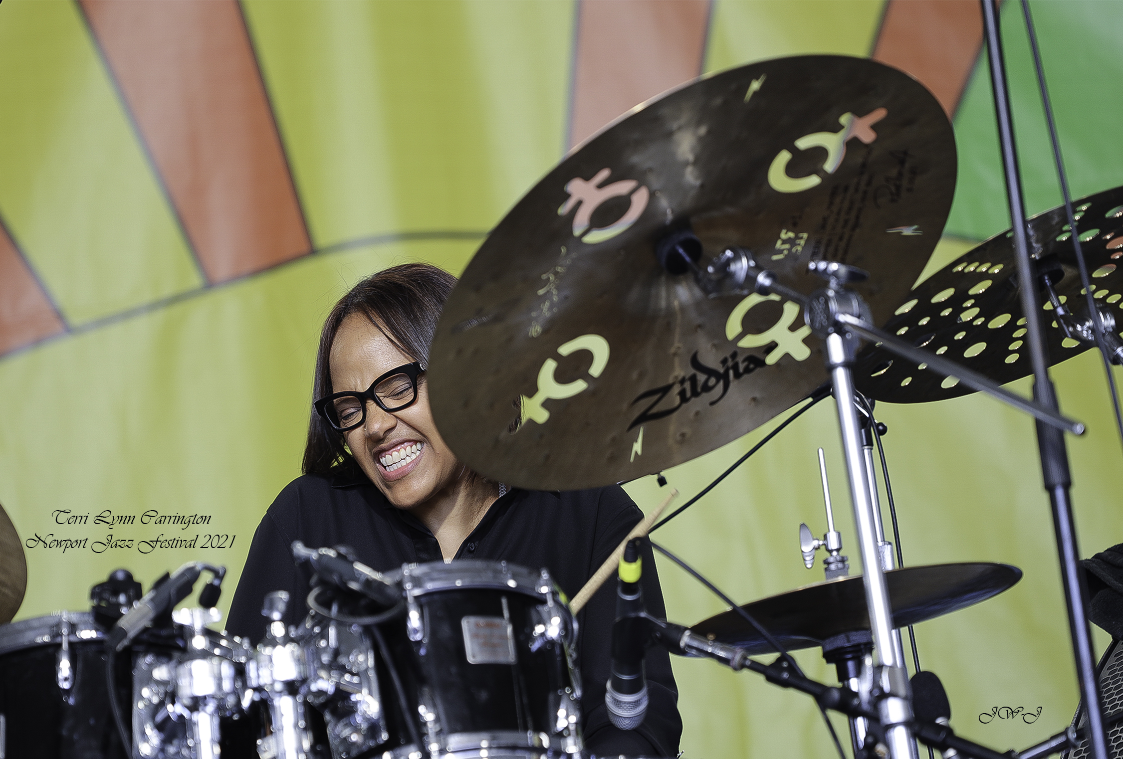Tony Lynn Carrington behind her drum-set performing at the Newport Jazz Festival, big smile on her face and deeply entranced with the music