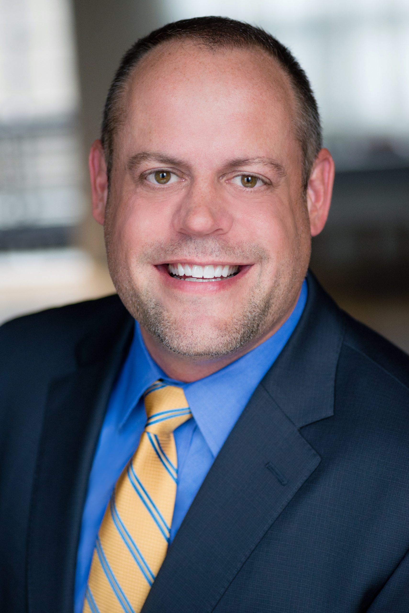 Full Color Headshot of Rob Hunden, Economic Development Professional and Business Owner from Chicago, IL. Gold striped tie, blue shirt and sport coat